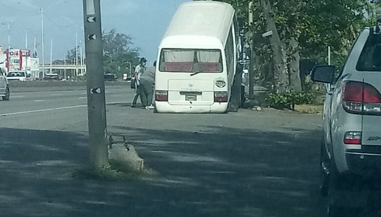 Este autobús de la UNET es levantado por una grúa de la DIGESETT luego de ser retenido e inautado en las inmediaciones del puente Juan Carlos II, en Santo Domingo Este.
